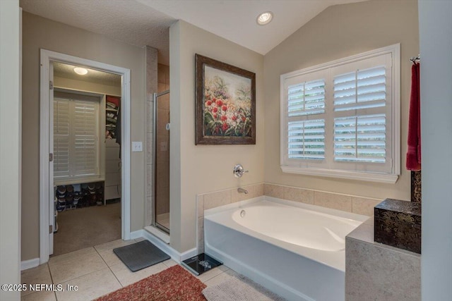 bathroom with lofted ceiling, tile patterned flooring, independent shower and bath, and a textured ceiling