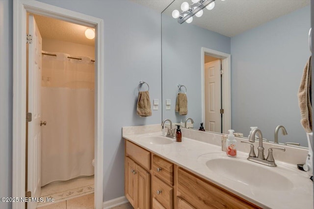 bathroom featuring vanity, tile patterned floors, and a textured ceiling
