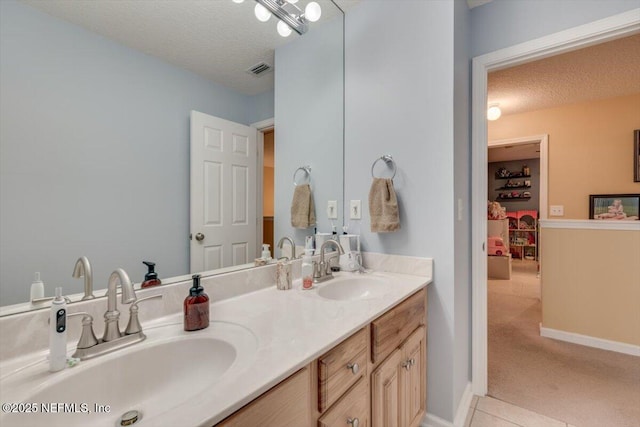 bathroom featuring vanity, tile patterned flooring, and a textured ceiling