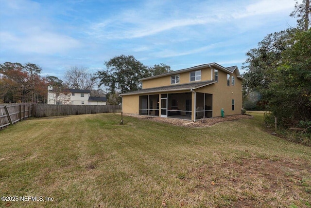back of property with a sunroom and a lawn