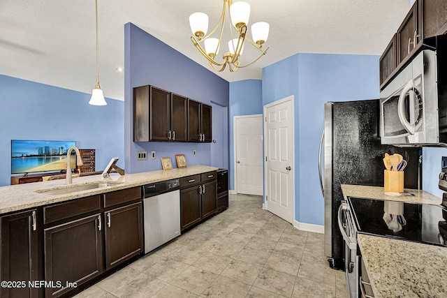 kitchen featuring dark brown cabinets, appliances with stainless steel finishes, a sink, and decorative light fixtures