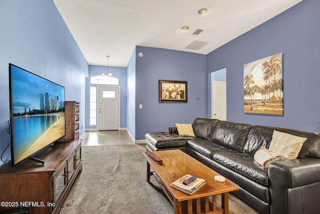 carpeted living room featuring a chandelier, visible vents, a textured ceiling, and baseboards