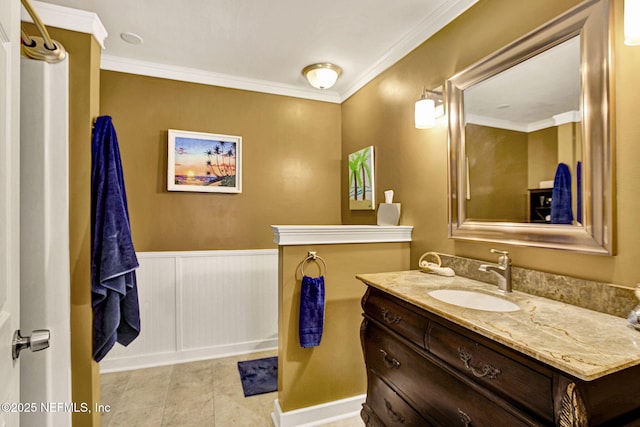 bathroom featuring ornamental molding, tile patterned flooring, a wainscoted wall, and vanity