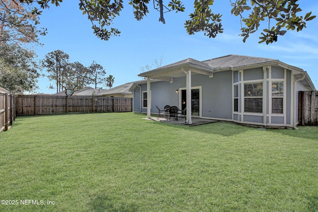 back of house featuring a patio area, a fenced backyard, a yard, and stucco siding