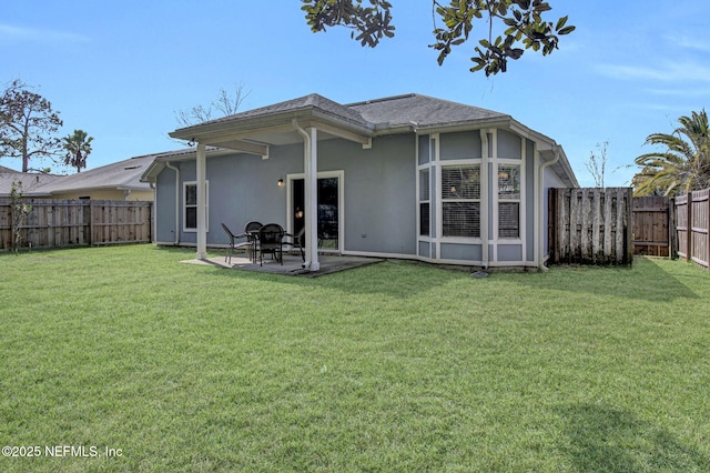 rear view of house with a patio, a yard, a fenced backyard, and stucco siding