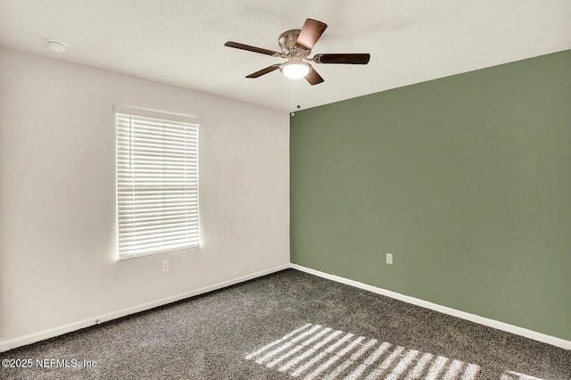 empty room featuring ceiling fan and dark carpet