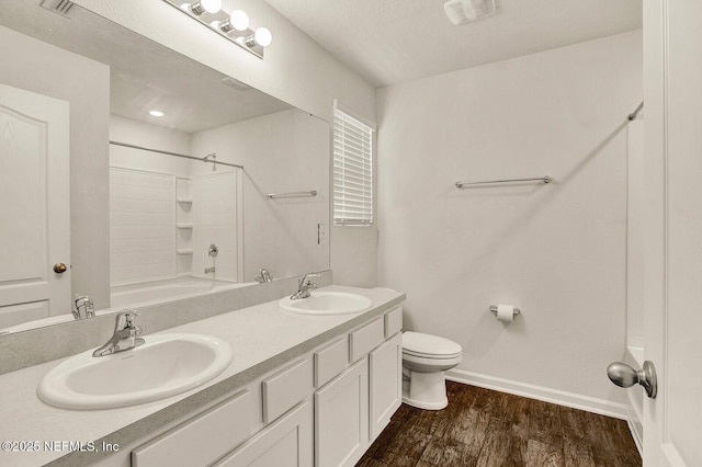 full bathroom featuring a textured ceiling, vanity, shower / bath combination, toilet, and hardwood / wood-style flooring