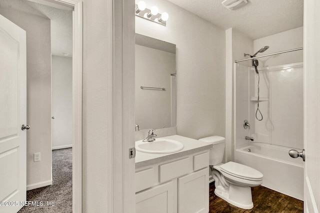 full bathroom featuring toilet,  shower combination, wood-type flooring, a textured ceiling, and vanity