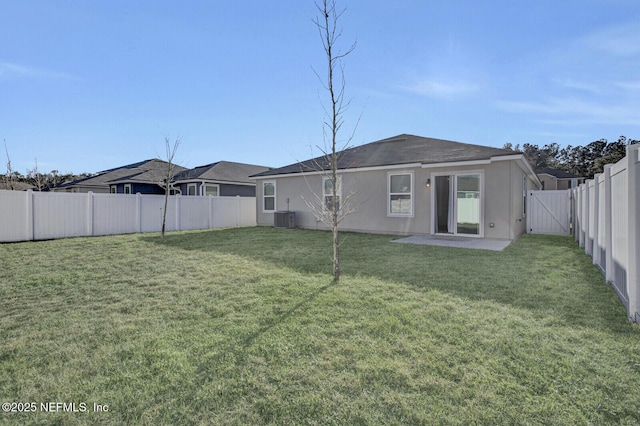 back of property with central AC unit, a yard, and a patio