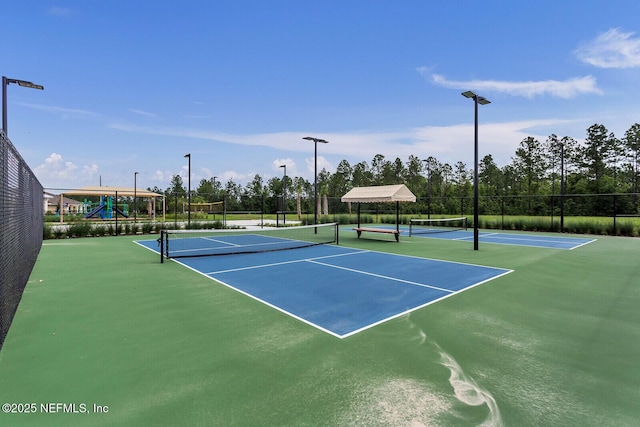 view of tennis court featuring a playground