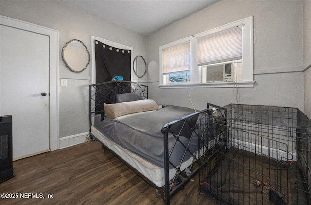 bedroom with cooling unit and dark hardwood / wood-style floors