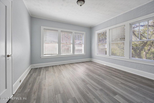 spare room with hardwood / wood-style floors and a textured ceiling