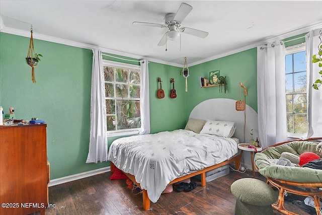 bedroom featuring multiple windows, dark wood-type flooring, ornamental molding, and ceiling fan