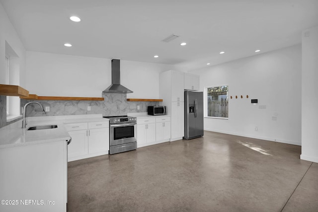 kitchen featuring sink, white cabinetry, wall chimney range hood, and appliances with stainless steel finishes