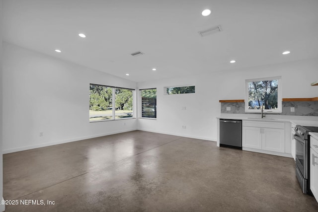 kitchen with appliances with stainless steel finishes, lofted ceiling, white cabinetry, tasteful backsplash, and sink