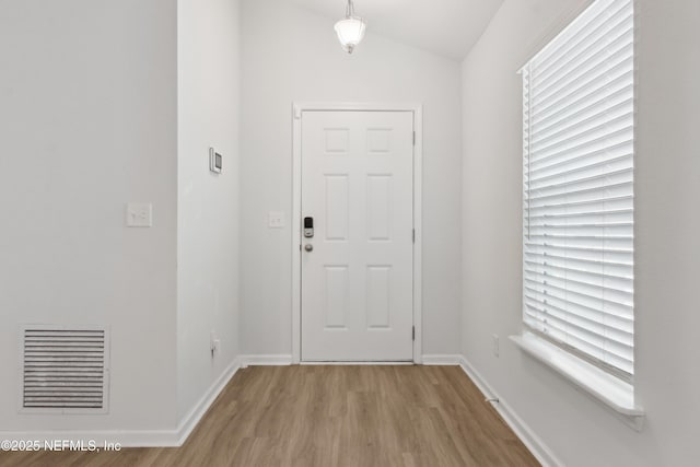 entryway featuring light hardwood / wood-style floors and vaulted ceiling