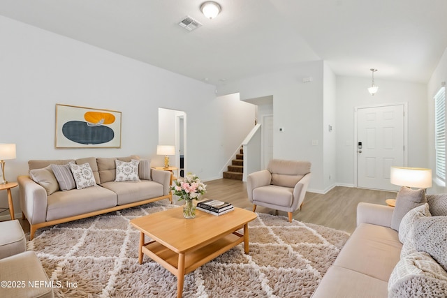 living room with lofted ceiling and light hardwood / wood-style flooring