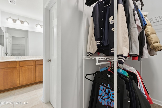 spacious closet featuring light tile patterned flooring and sink