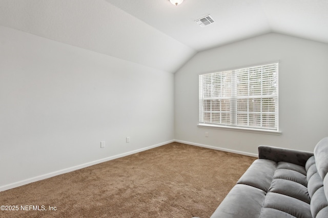 unfurnished room featuring lofted ceiling and carpet floors