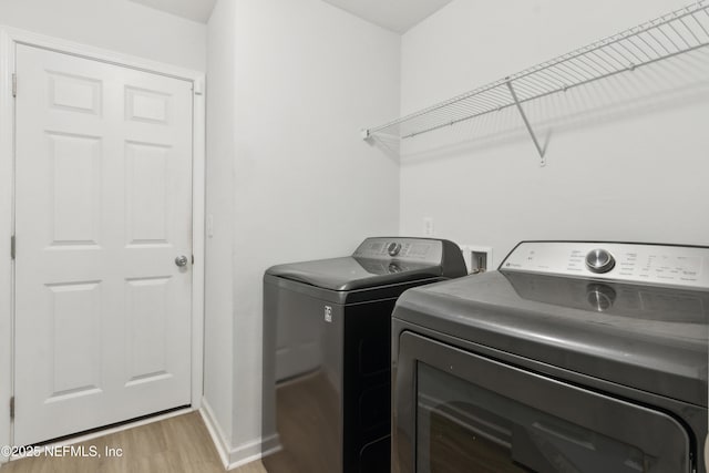 laundry area featuring independent washer and dryer and light wood-type flooring