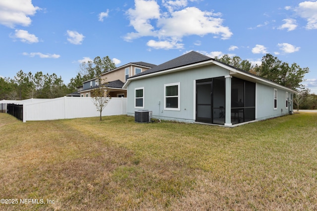 rear view of house featuring a yard, a sunroom, and central AC