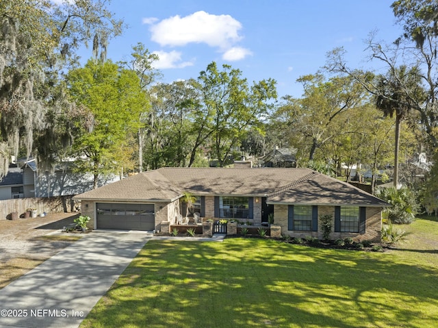 view of front of home with driveway, brick siding, an attached garage, and a front yard