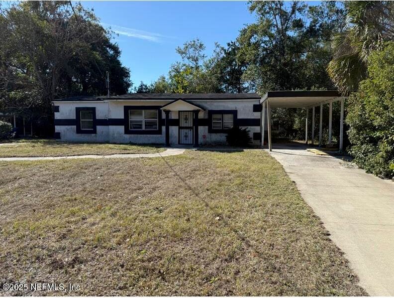 view of front of house with a front yard and a carport