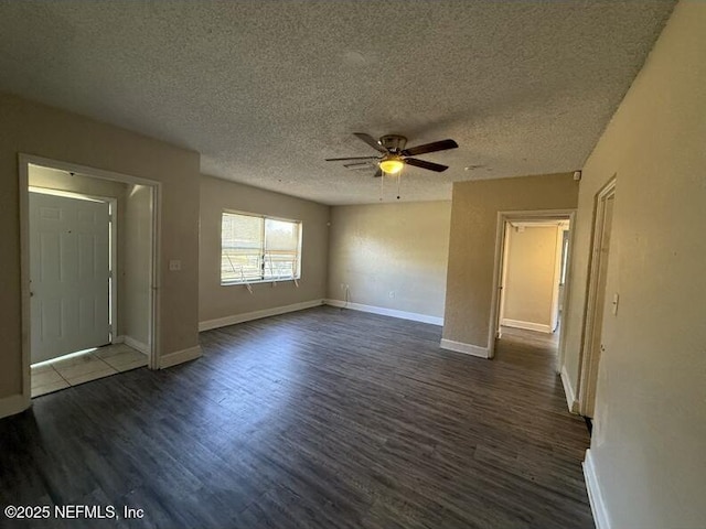 empty room with ceiling fan, dark hardwood / wood-style flooring, and a textured ceiling