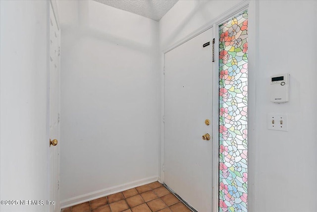 tiled entryway featuring a textured ceiling