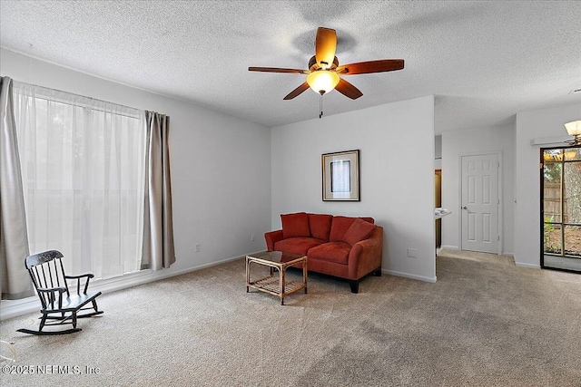 living room with ceiling fan, light colored carpet, and a textured ceiling