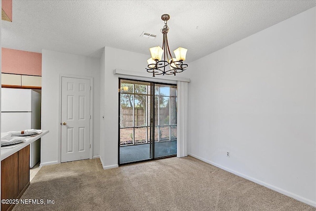 unfurnished dining area featuring a textured ceiling, light carpet, and a notable chandelier