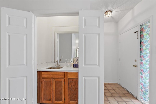 bathroom featuring vanity, a textured ceiling, and tile patterned flooring