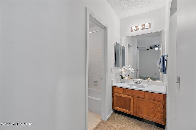 bathroom with vanity, ceiling fan, a textured ceiling, and shower / bathing tub combination