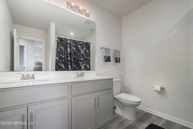 bathroom with curtained shower, hardwood / wood-style flooring, toilet, and vanity