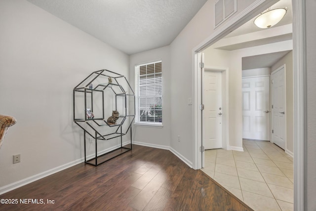 entrance foyer with hardwood / wood-style floors and a textured ceiling