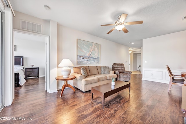 living room with ceiling fan and dark hardwood / wood-style floors