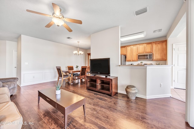 living room with hardwood / wood-style flooring and ceiling fan with notable chandelier