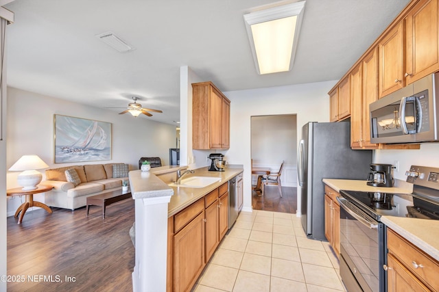 kitchen featuring sink, ceiling fan, kitchen peninsula, stainless steel appliances, and light hardwood / wood-style floors