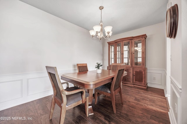 dining room with dark hardwood / wood-style flooring and a chandelier