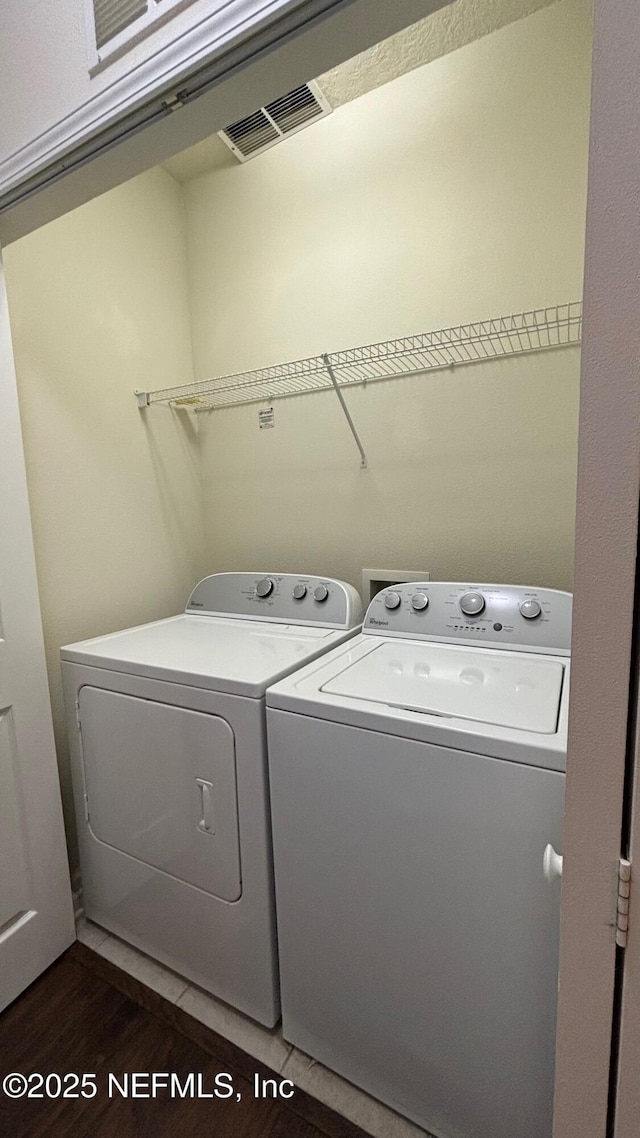 clothes washing area with dark hardwood / wood-style flooring and washer and dryer