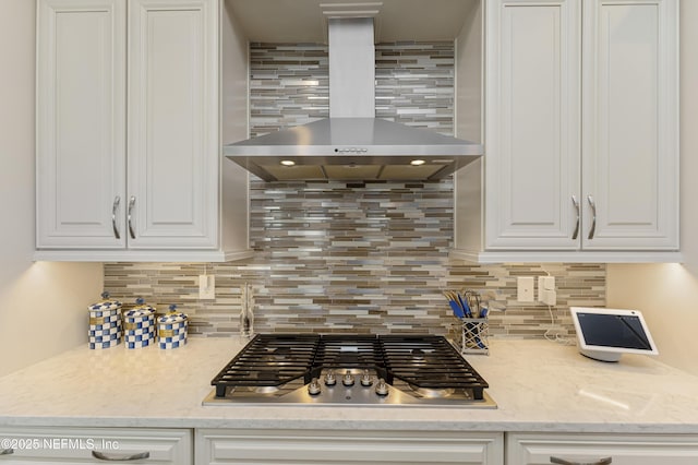 kitchen with white cabinetry, stainless steel gas cooktop, decorative backsplash, and wall chimney exhaust hood