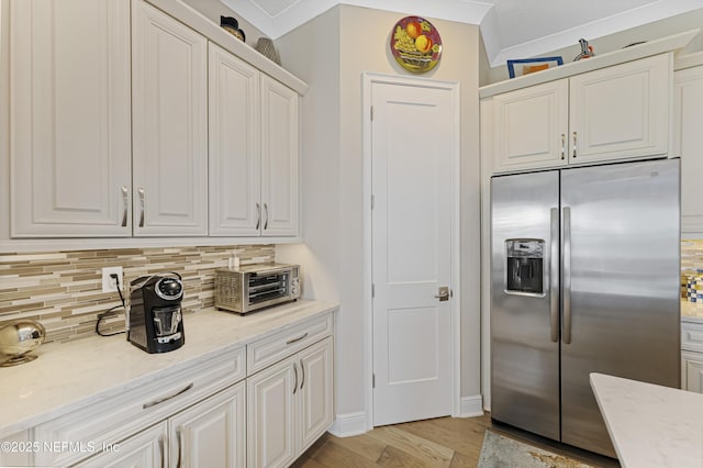 kitchen featuring white cabinetry and stainless steel fridge with ice dispenser