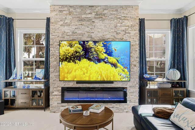 living area with a stone fireplace and ornamental molding