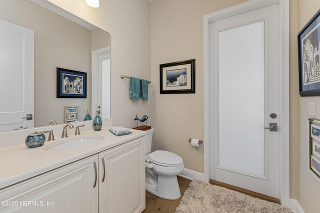 bathroom featuring vanity, toilet, and hardwood / wood-style floors