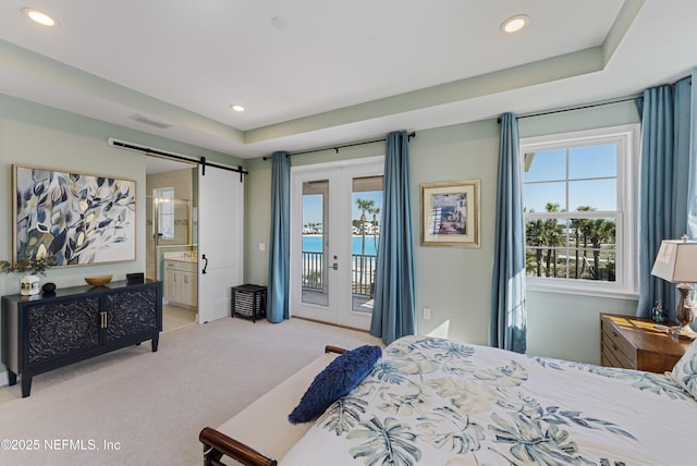 bedroom featuring ensuite bathroom, access to exterior, a barn door, light carpet, and french doors