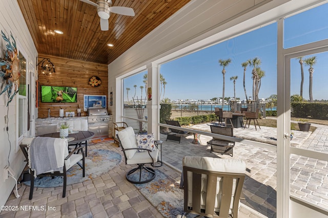 view of patio with area for grilling, a grill, and ceiling fan