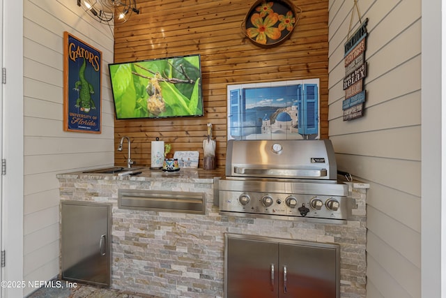 bar with sink, light stone counters, and wooden walls