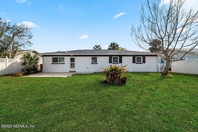 rear view of house with a patio area and a lawn