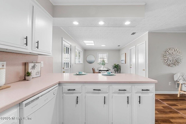 kitchen featuring kitchen peninsula, dishwasher, white cabinets, dark hardwood / wood-style floors, and ornamental molding