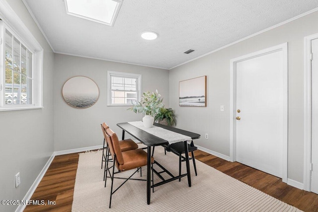 dining area featuring crown molding, a textured ceiling, and wood-type flooring